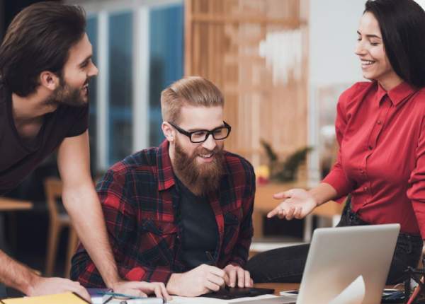 Team collaborating on laptop, building a unified ArchExtra AI framework.