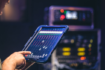 Industrial operator monitoring OT equipment data and operational signals on a tablet